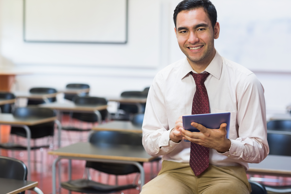 Portrait of a smiling education consultant with tablet in the classroom